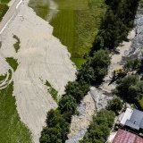 Une vue aérienne montre des ouvriers avec des pelleteuses travaillant sur la coulée de lave torrentielle provenant du torrent du Fregnoley dans le Haut Val de Bagnes